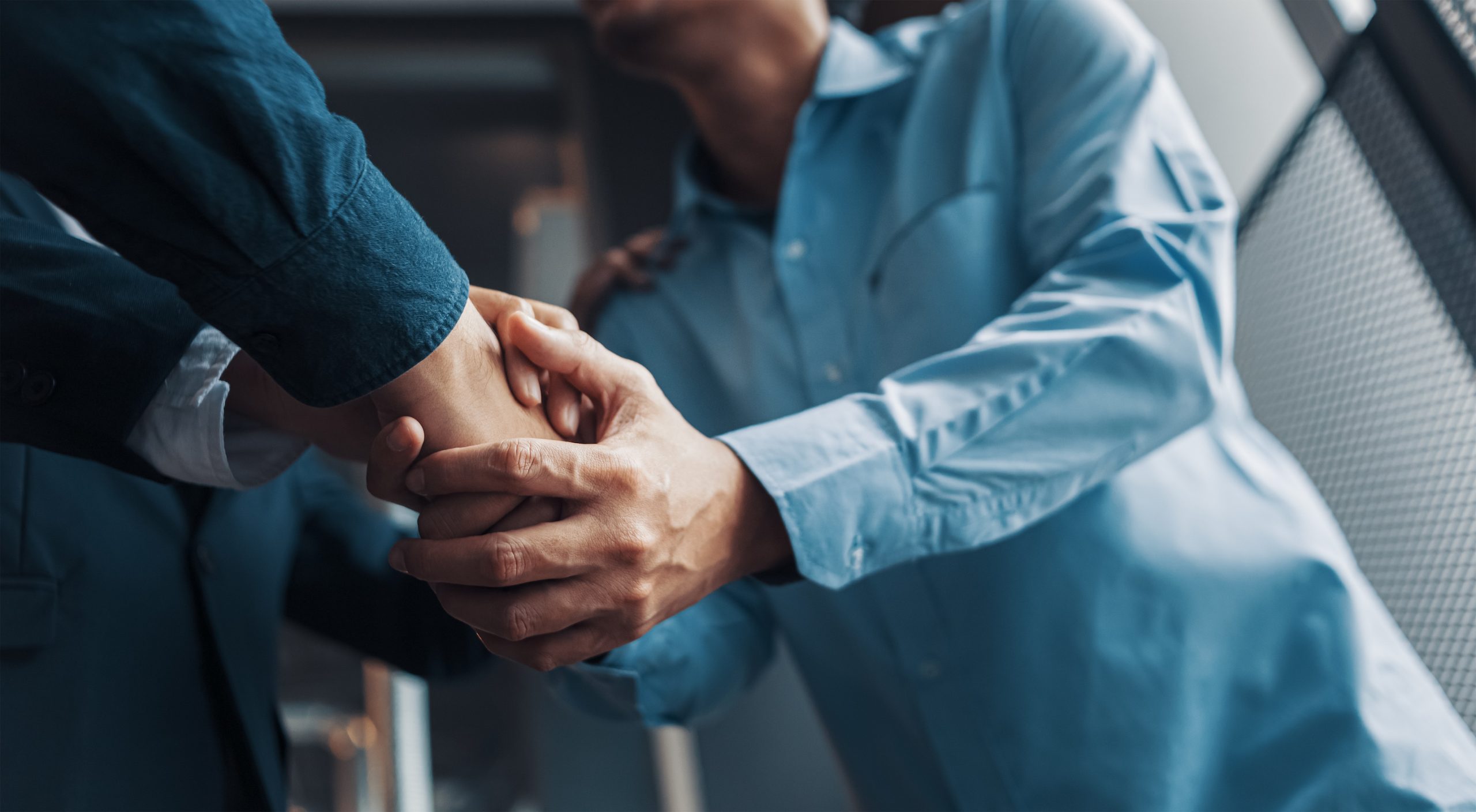 Local attorney shakes hands warmly with a happy client.